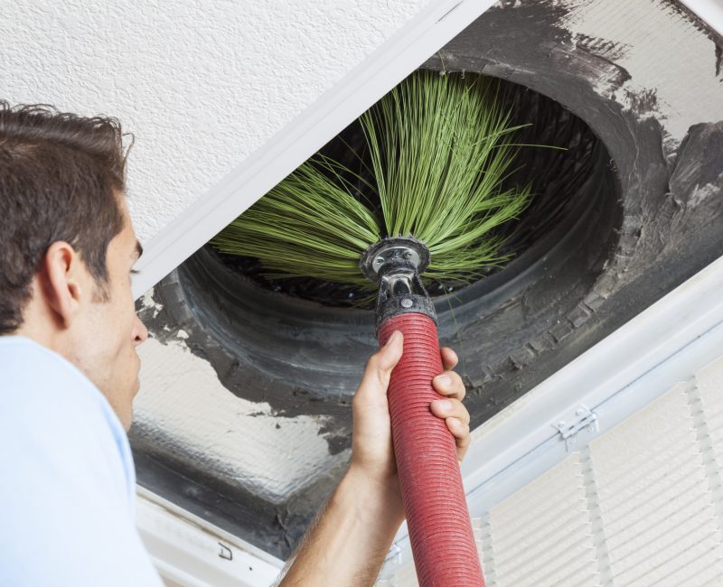 Man cleaning air ducts in home.